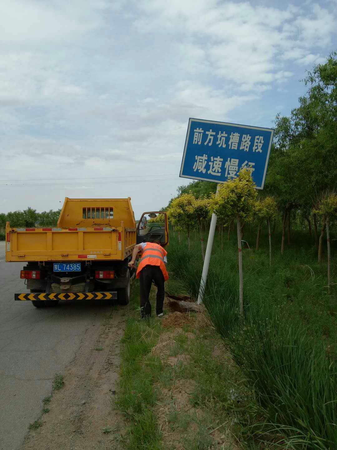 (养护人员检查公路标志)